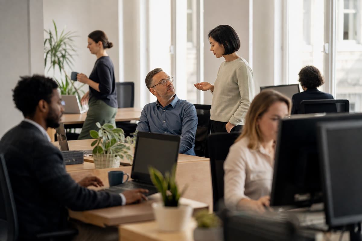 Staff working normally at their desks in a bright open-plan office on an ordinary weekday.