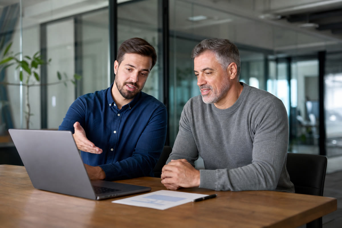 IT consultant and a business owner reviewing a restore test report together on a laptop.